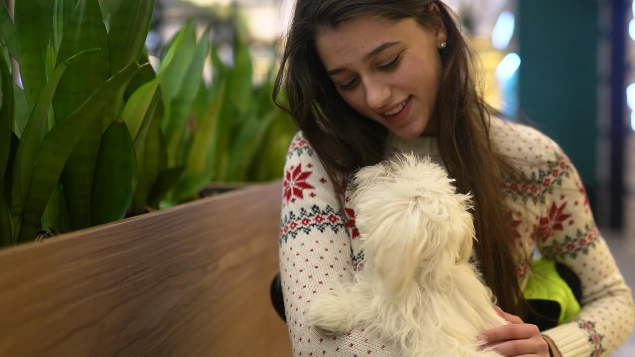 A pet parent cuddling her fluffy white dog
